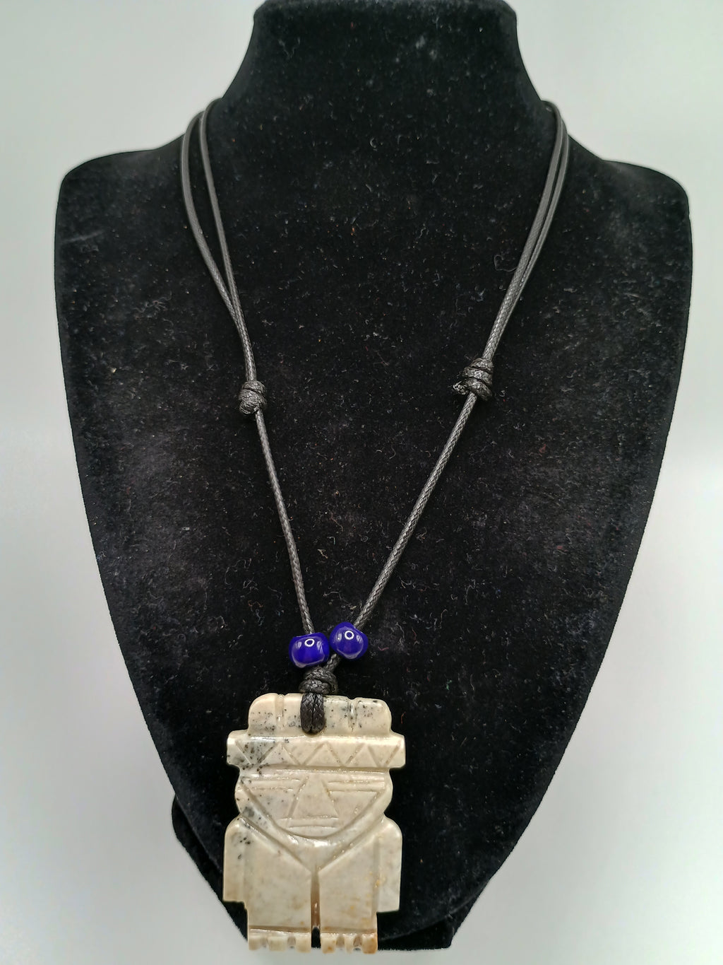 Hand-carved natural stone necklace with an ancestral style pendant and adjustable cord.
