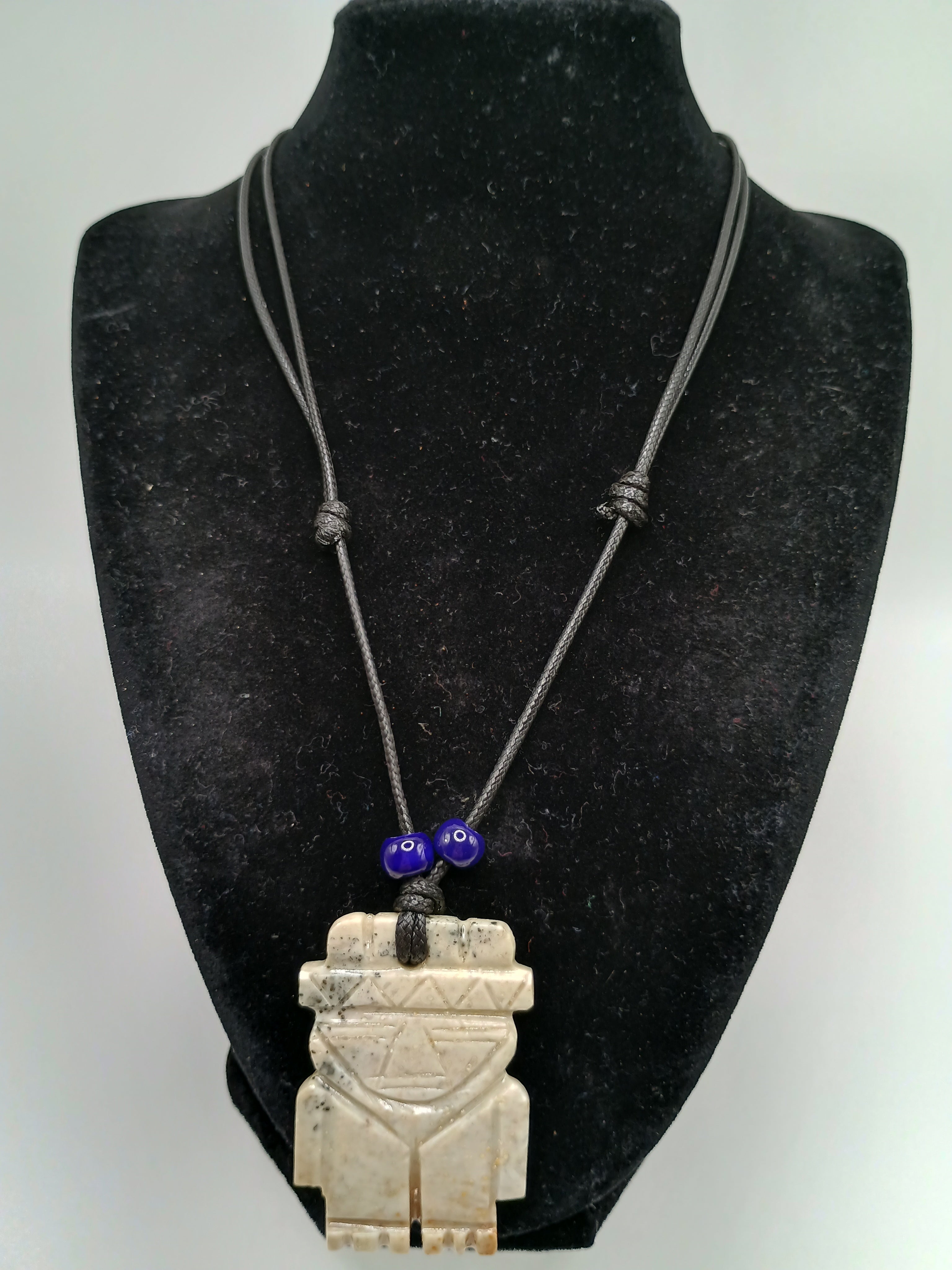 Hand-carved natural stone necklace with an ancestral style pendant and adjustable cord.