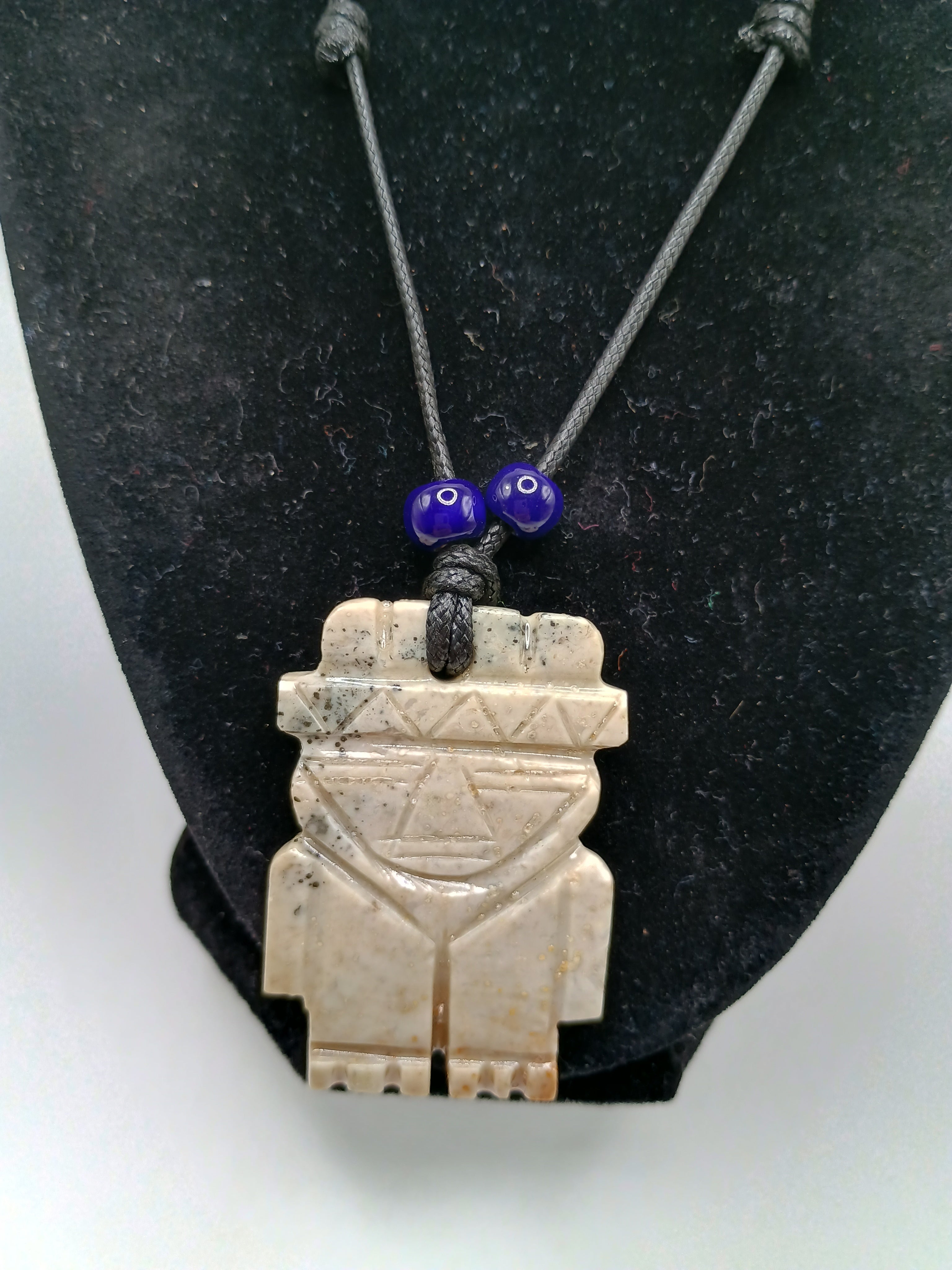 Hand-carved natural stone necklace with an ancestral style pendant and adjustable cord.