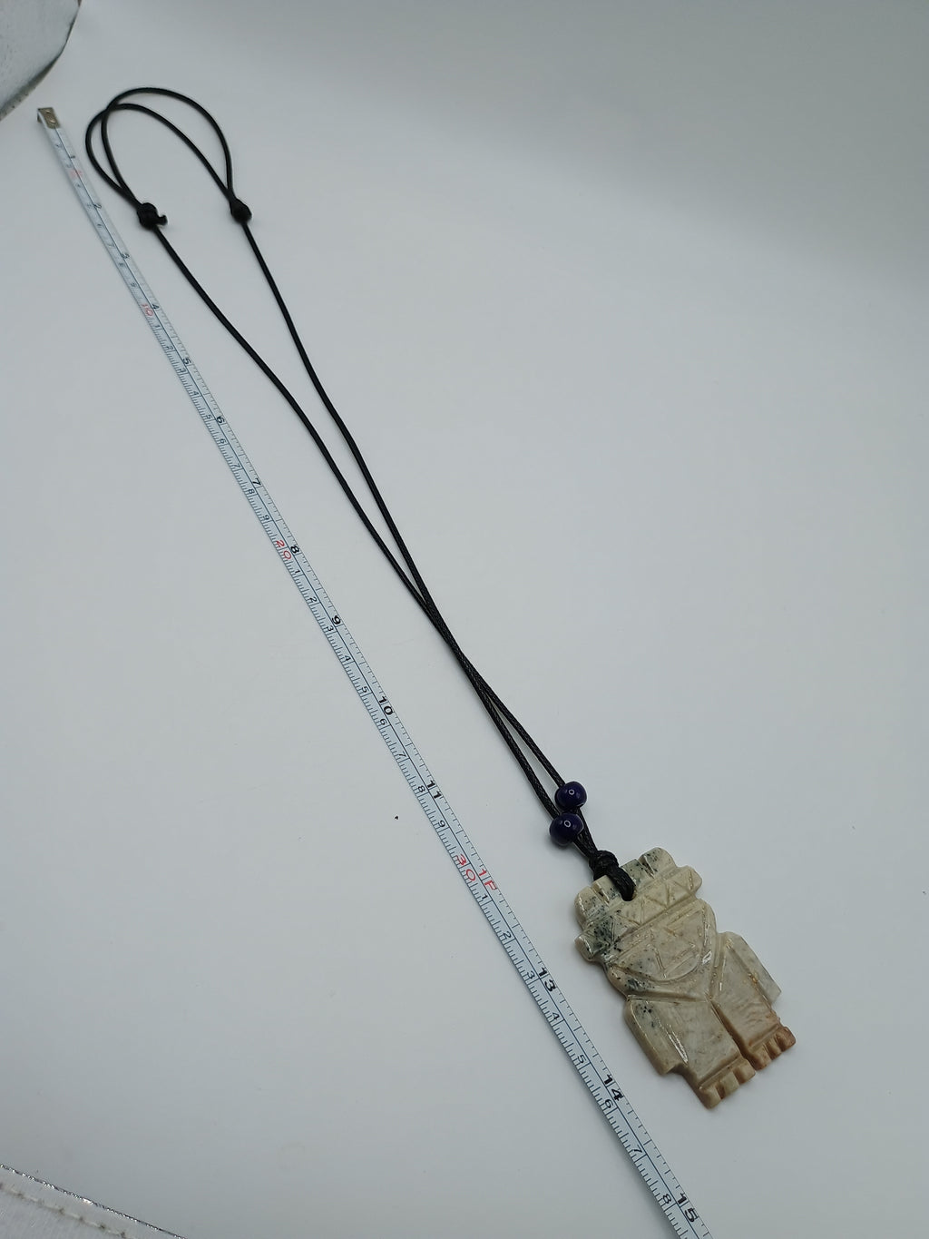 Hand-carved natural stone necklace with an ancestral style pendant and adjustable cord.