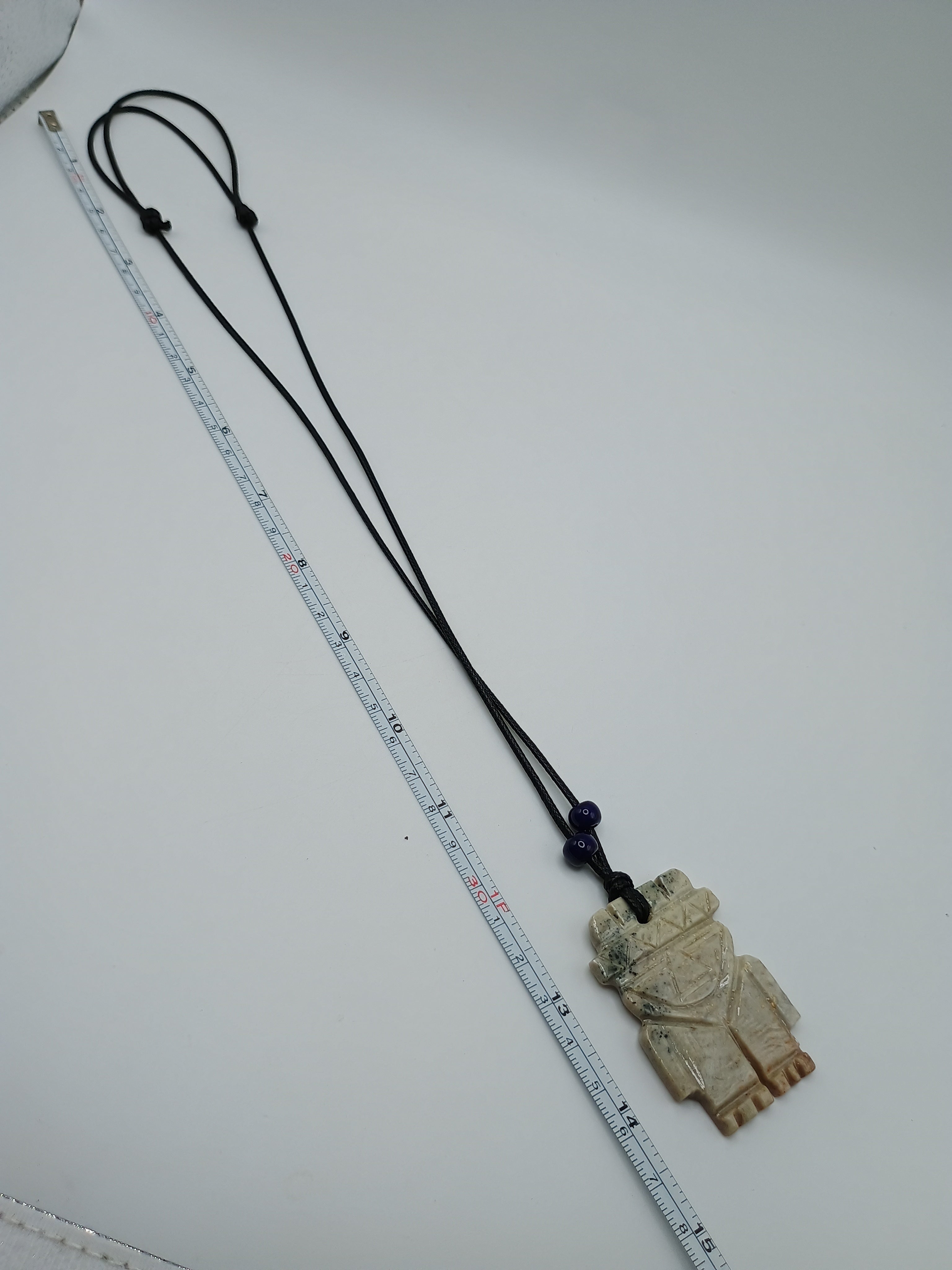 Hand-carved natural stone necklace with an ancestral style pendant and adjustable cord.